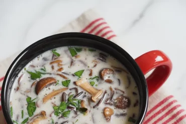 🍄✨ Cozy, hearty, and secretly light—this “Creamy” Wild Rice and Mushroom Soup is the ultimate cold-weather comfort food! Made in the slow cooker with wild rice, fresh mushrooms, and puréed cannellini beans for creaminess (without heavy dairy), it’s a wholesome, satisfying meal perfect for chilly days. #SlowCookerSoup #WildRiceSoup #HealthyComfortFood #MeatlessMeals #CozyRecipes