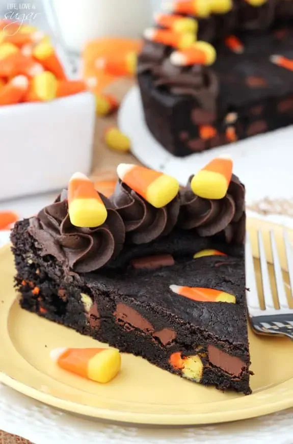 Candy Corn Chocolate Chip Cookie Cake - Who doesn't love a giant chocolate cookie? Especially when it's turned into a cake and laced with candy corns. Oh my!