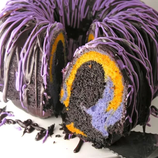 Halloween Bundt Cake - Creepy colours all swirled together inside a bundt cake and drizzled with gooey frosting equals the perfect Halloween cake for a kid's party!