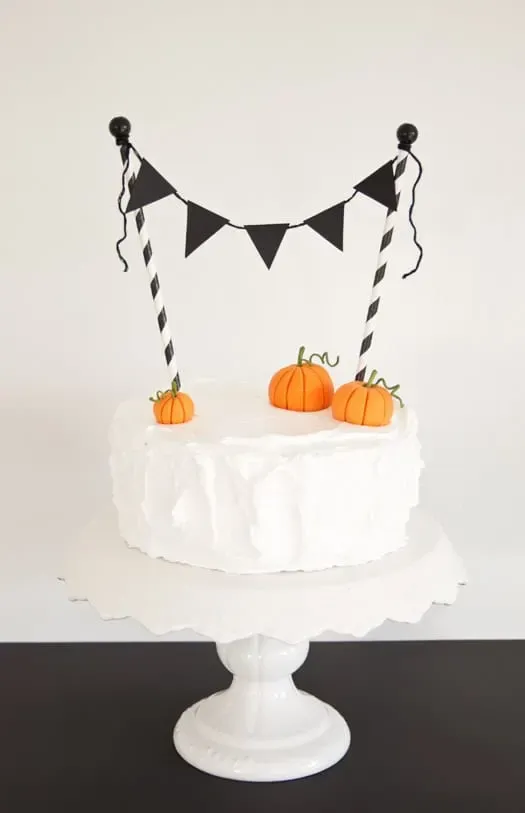 Vintage Halloween Cake - Wow how fabulous is this cake? Love that it is so simple with that white meringue frosting but add some black and white straws and mini bunting and you've got yourself a really striking Halloween cake!